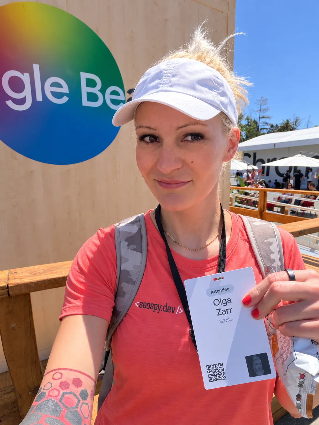 Olga Zarr, SEO consultant, holding her attendee badge at an outdoor Google event.